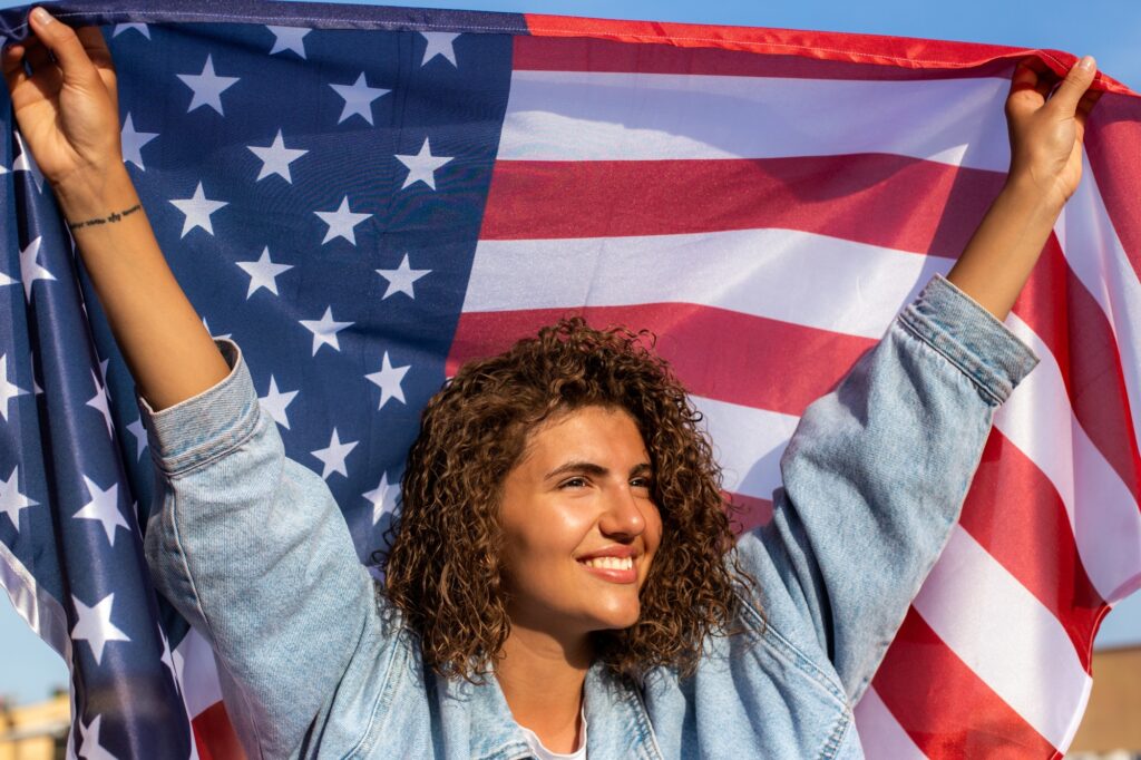 Datapro-usa-happy-beautiful-diverse-curly-haired-woman-holding-united-states-of-america-flag Datapro-usa-happy-beautiful-diverse-curly-haired-woman-holding-united-states-of-america-flag